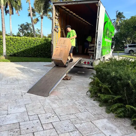 Movers loading a truck by ramp