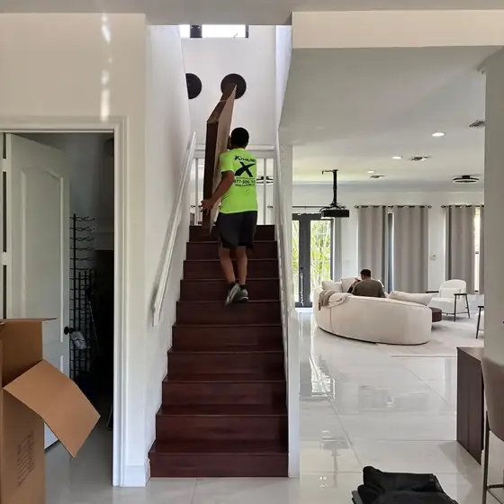 Mover carrying a box down the stairs